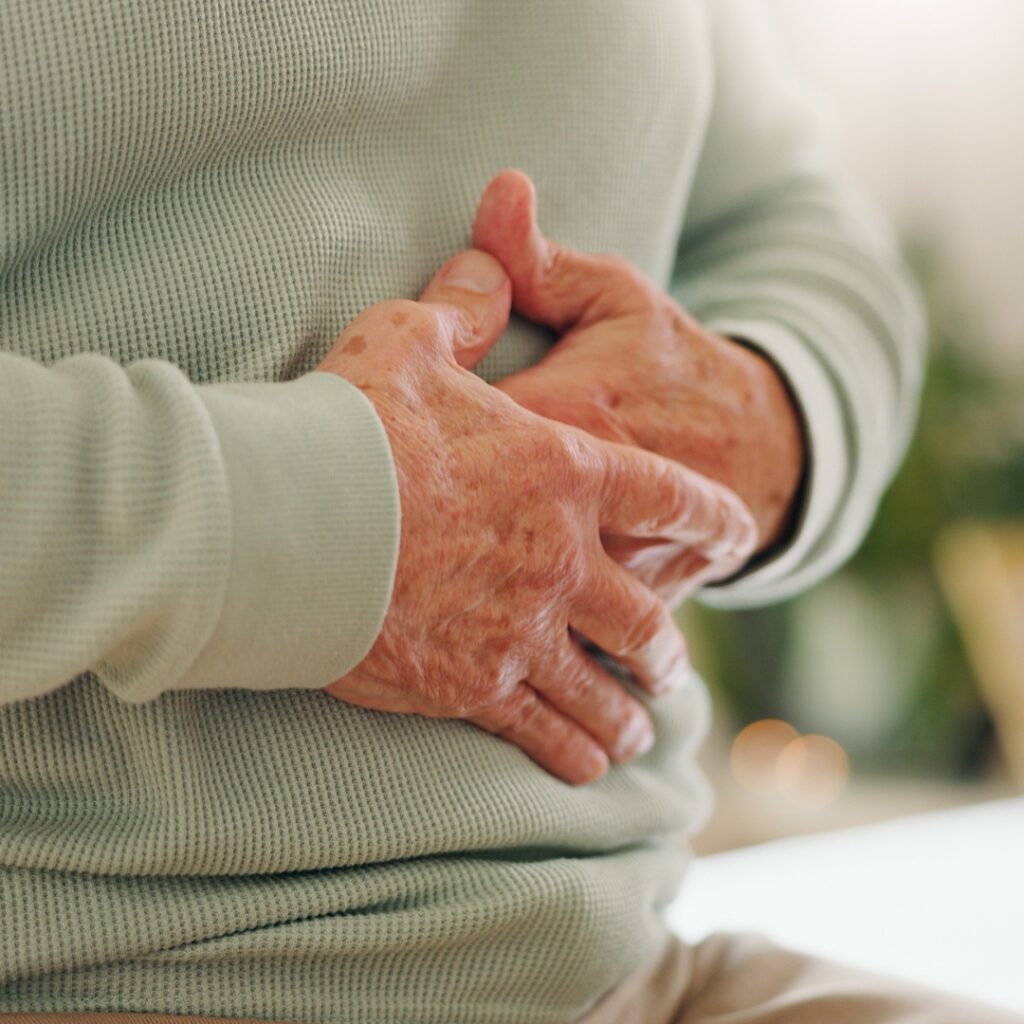 An older man grips his stomach.