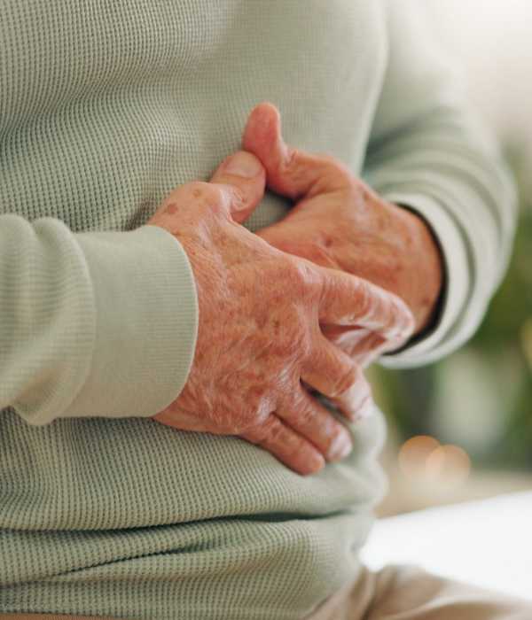 An older man grips his stomach.