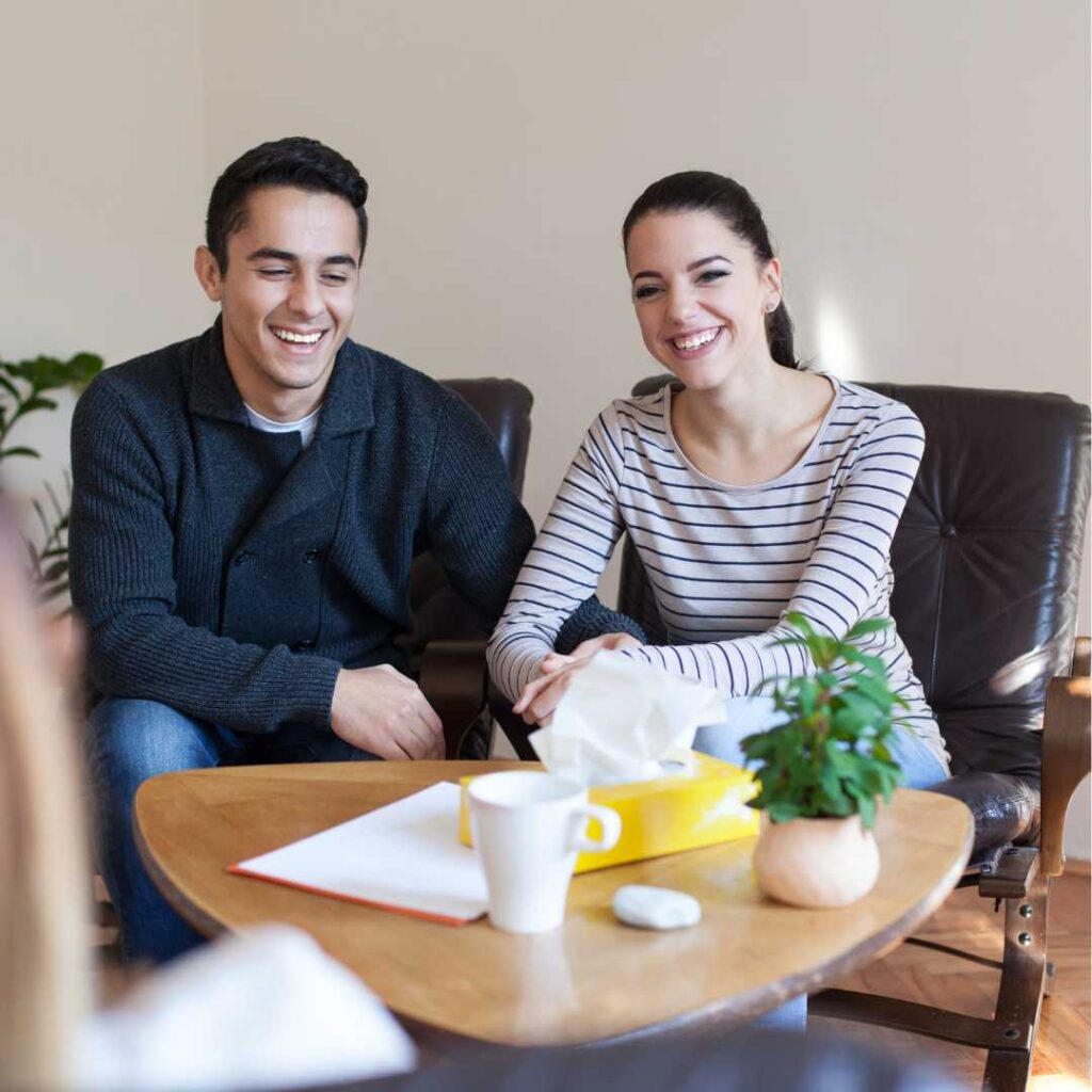 A couple sit on a couch and listen to their dietitian.