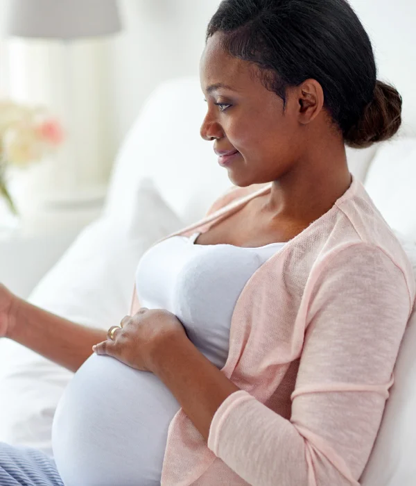 A pregnant woman looks at her phone.